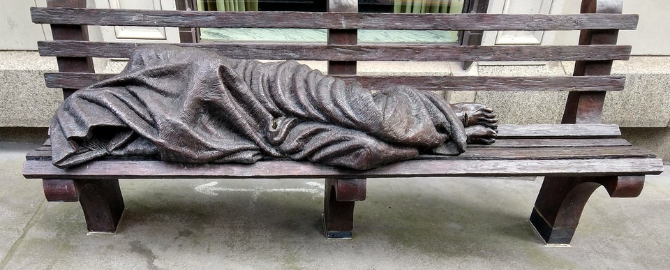 estatua de vagabundo en banco